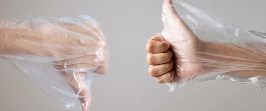 Na imagem há duas mãos, de duas pessoas de pele branca, envoltas de um saco plástico. A imagem representa o título da matéria, sobre a suspensão da reciclagem química no EUA