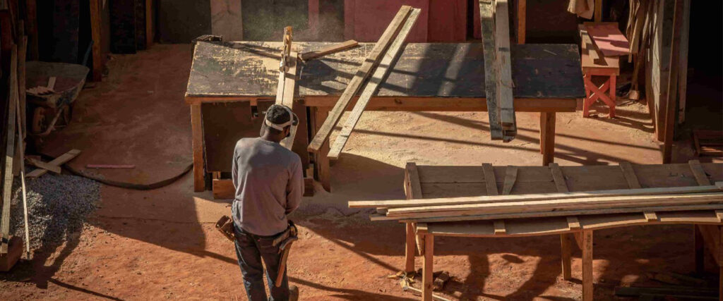 Na imagem aparece um homem trabalhando no setor de construção. A imagem representa a situação  das pequenas indústrias brasileiras