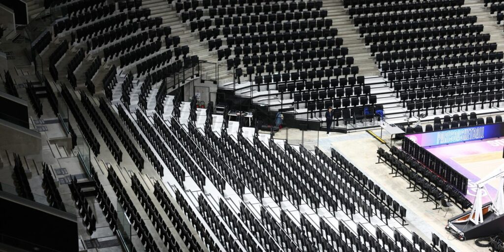 Na imagem aparecem cadeiras pretas no centro olímpico, representando as cadeiras de plástico reciclado