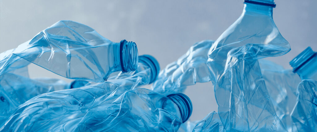 Na imagem aparecem garrafas de plástico na tonalidade azul